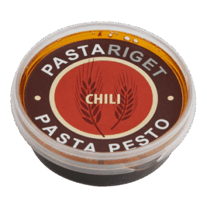 Rund beholder med gennemsigtigt låg, etiket med "Pastariget Chili Pesto" og chili grafik.