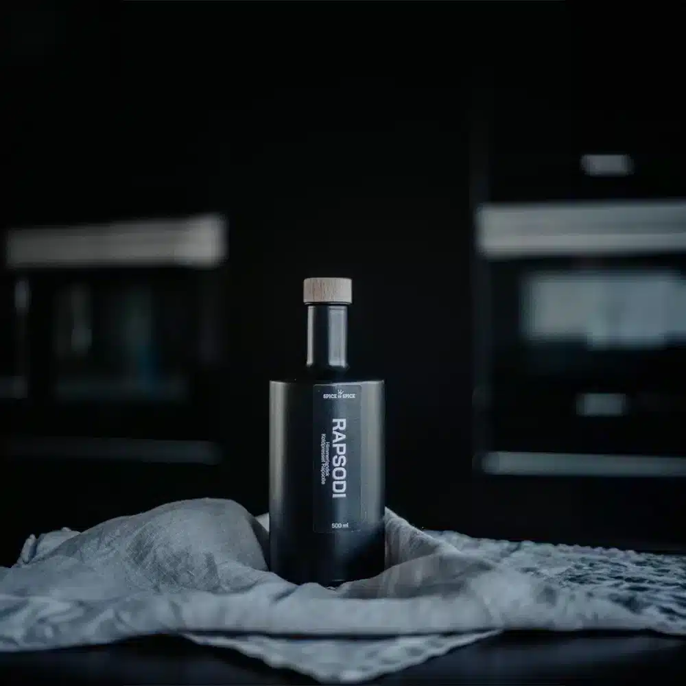 Spice by Spice, Himmerlandsk Rapsolie Mørk flaske med træprop og moderne etiket på en klud, enkel baggrund.