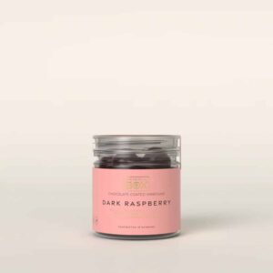 Lille cylinderformet beholder med pink label, "Dark Raspberry," håndlavet i Danmark.