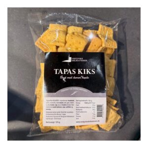 Pakke med Vestjyske Delikatesser Tapas Kiks, gennemsigtig emballage, sort label foran.